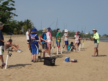 students with fishing rods on beach