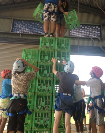 students standing on and around stack of crates